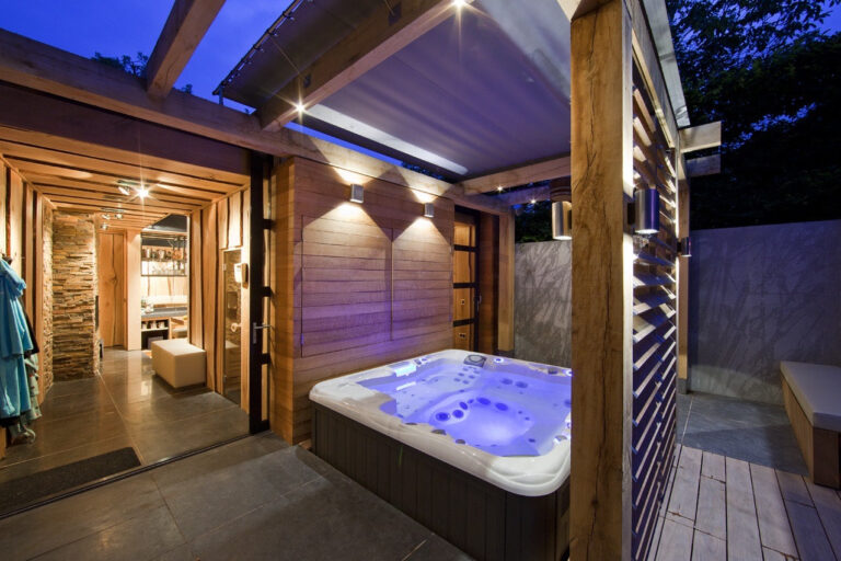 Jacuzzi buiten met sfeerverlichting en luxe wandafwerking