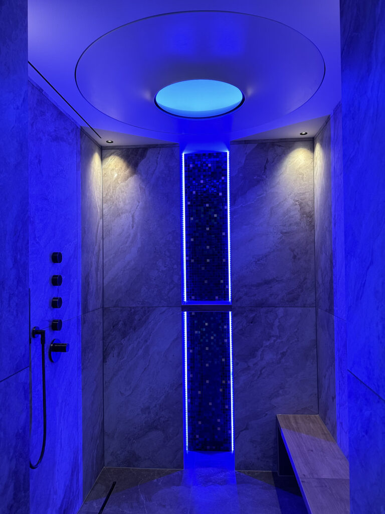 Stoomdouche met blauwe verlichting in wellnessruimte