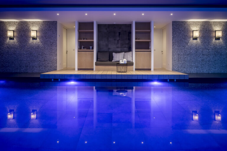 Wellness zwembad met avondverlichting en luxe wandafwerking