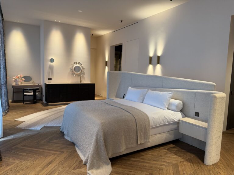Ruime slaapkamer met maatwerk bed, haard en houten vloer