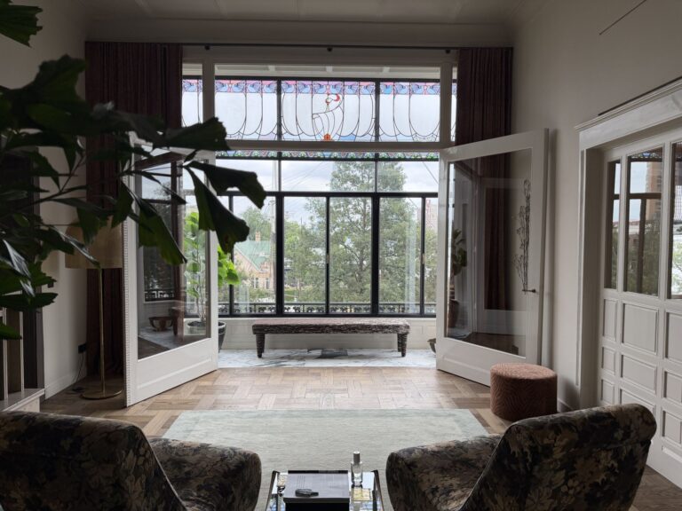 Zitkamer met grote ramen en zicht op het monumentale interieur